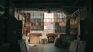 A warehouse studio so dim that the canvases against the walls disappear