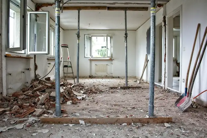 Before: a room gutted to the studs with temporary supports in place