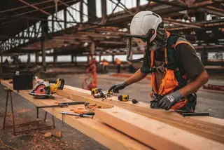 A worker cutting lumber on site